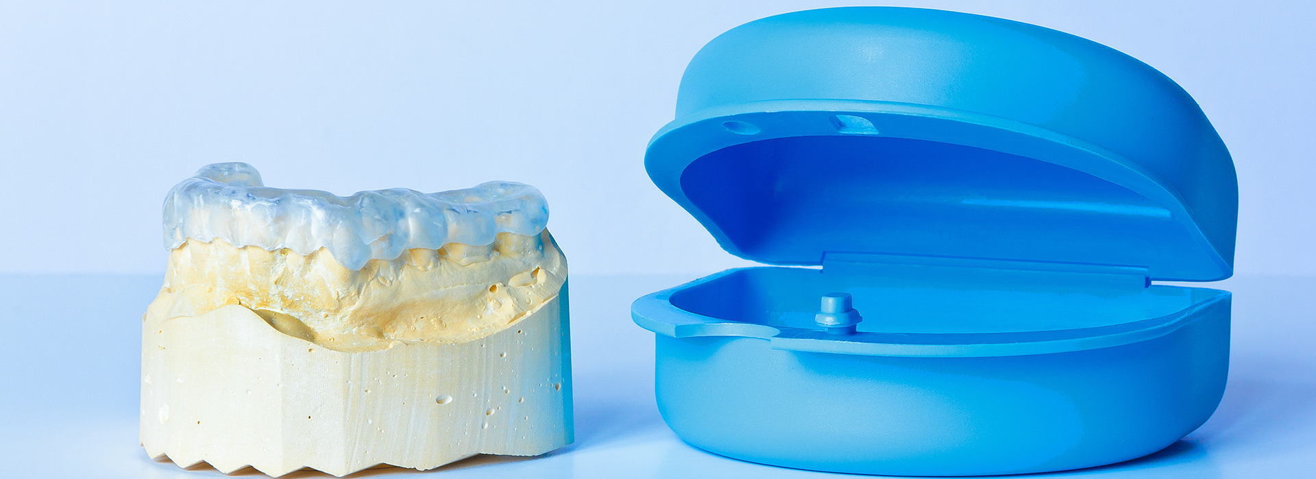 The image shows a blue dental mold next to a yellow dental model, both of which are commonly used in dental offices for creating customized dental appliances.